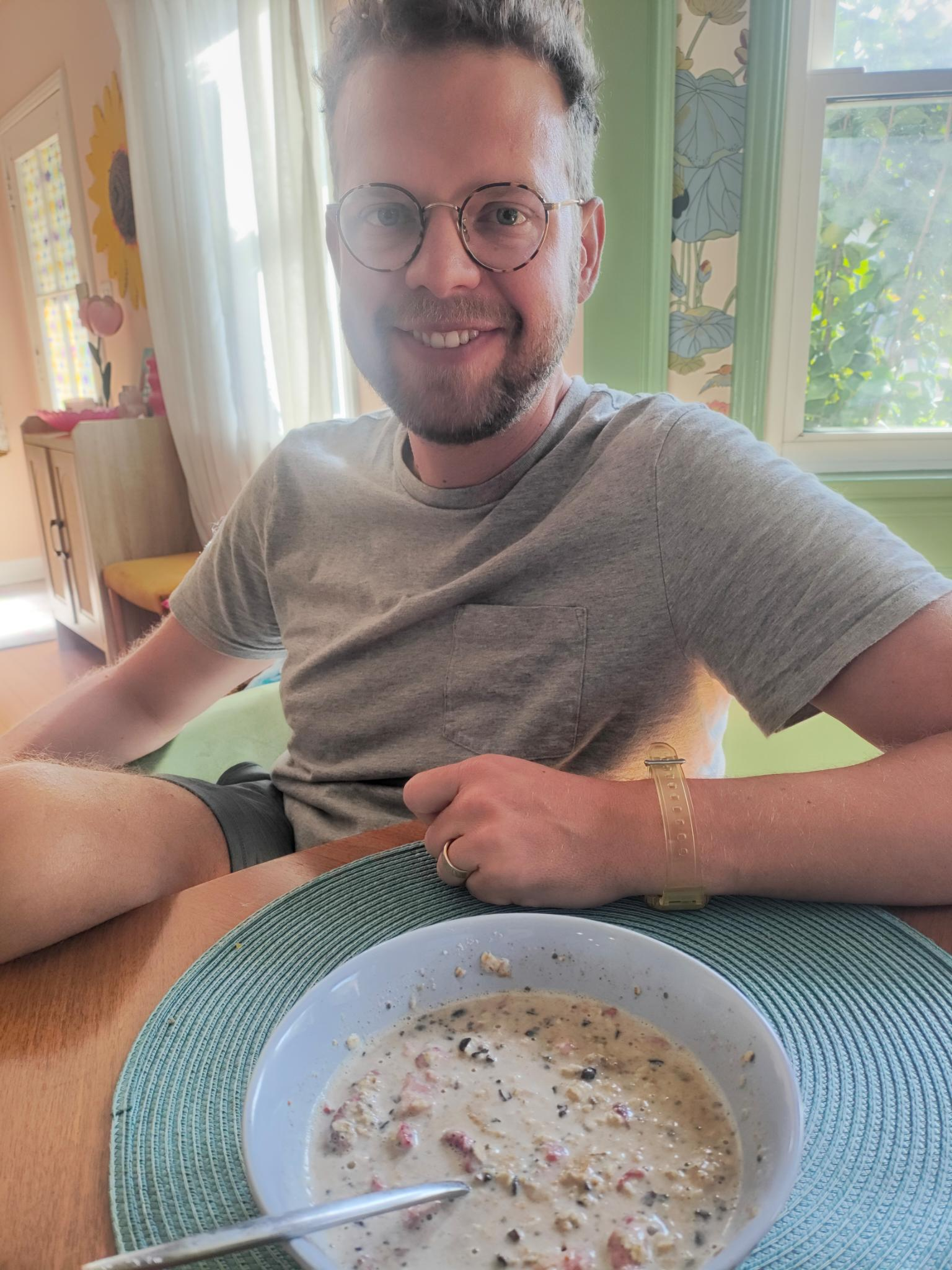 Alex at the kitchen table with a bowl of the instant oats, ready to eat